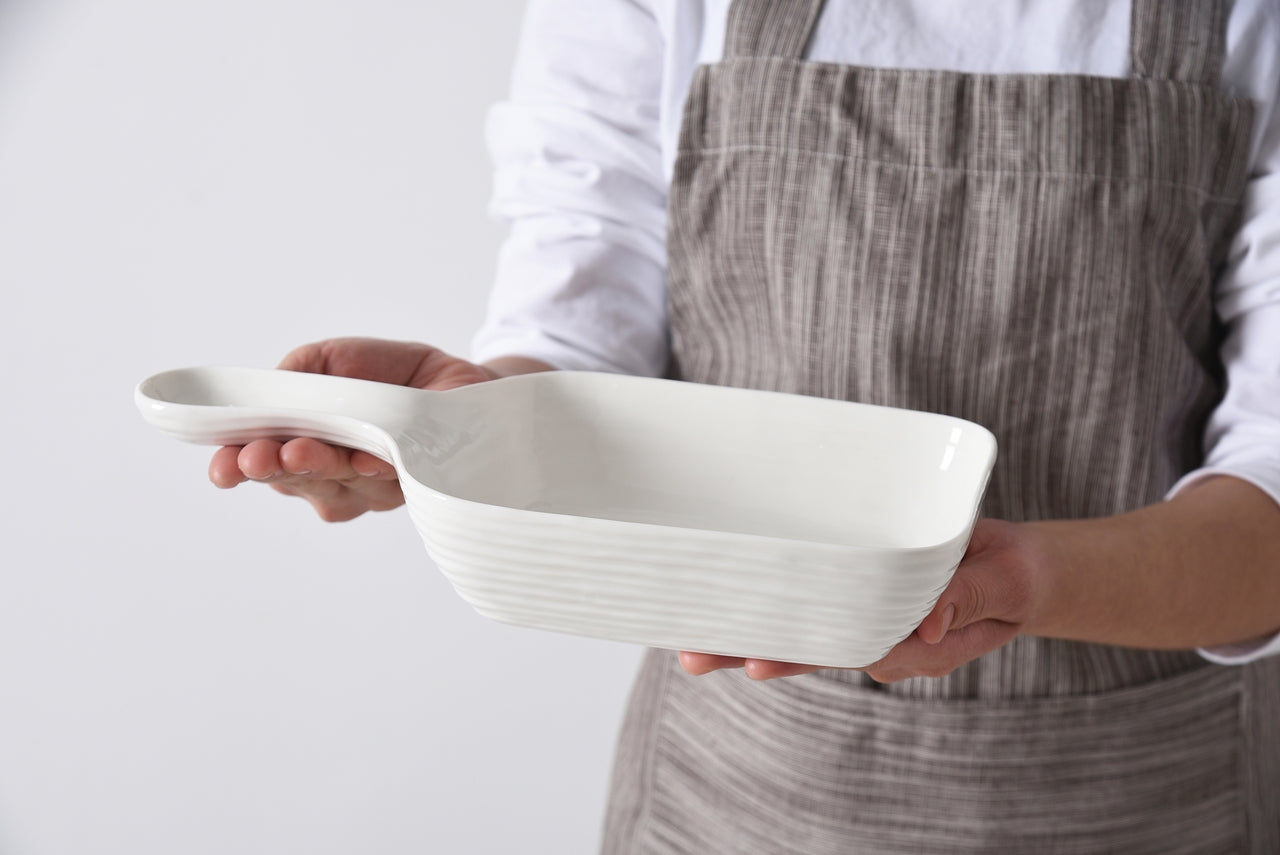 person holding the le blanc serving dish with handle