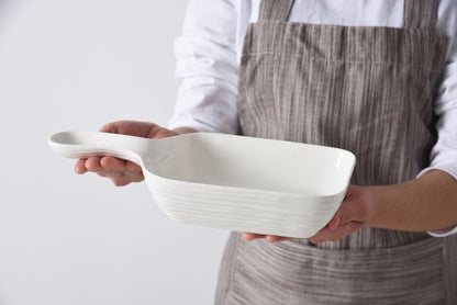 person holding the le blanc serving dish with handle