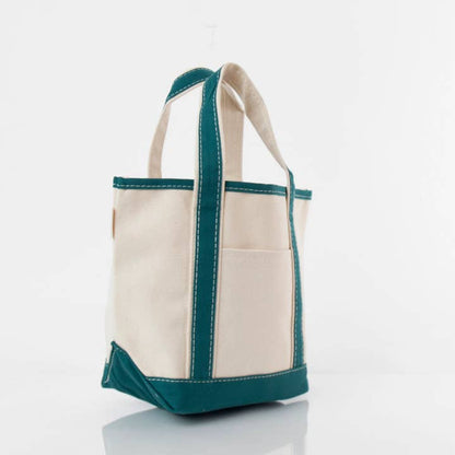 angled view of off white tote with teal green handles and trim