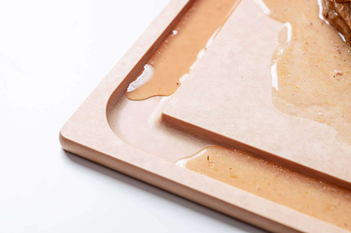 close-up of cutting board  with groove with liquid in it