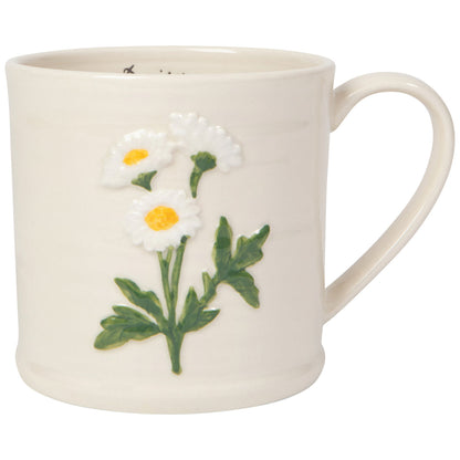 white mug with an embossed sprig of daisyon it