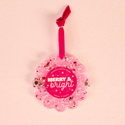 Pink Confetti round ornament frame shown on a beige background