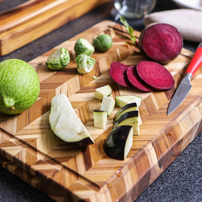 herringbone board with sliced veggies on it.