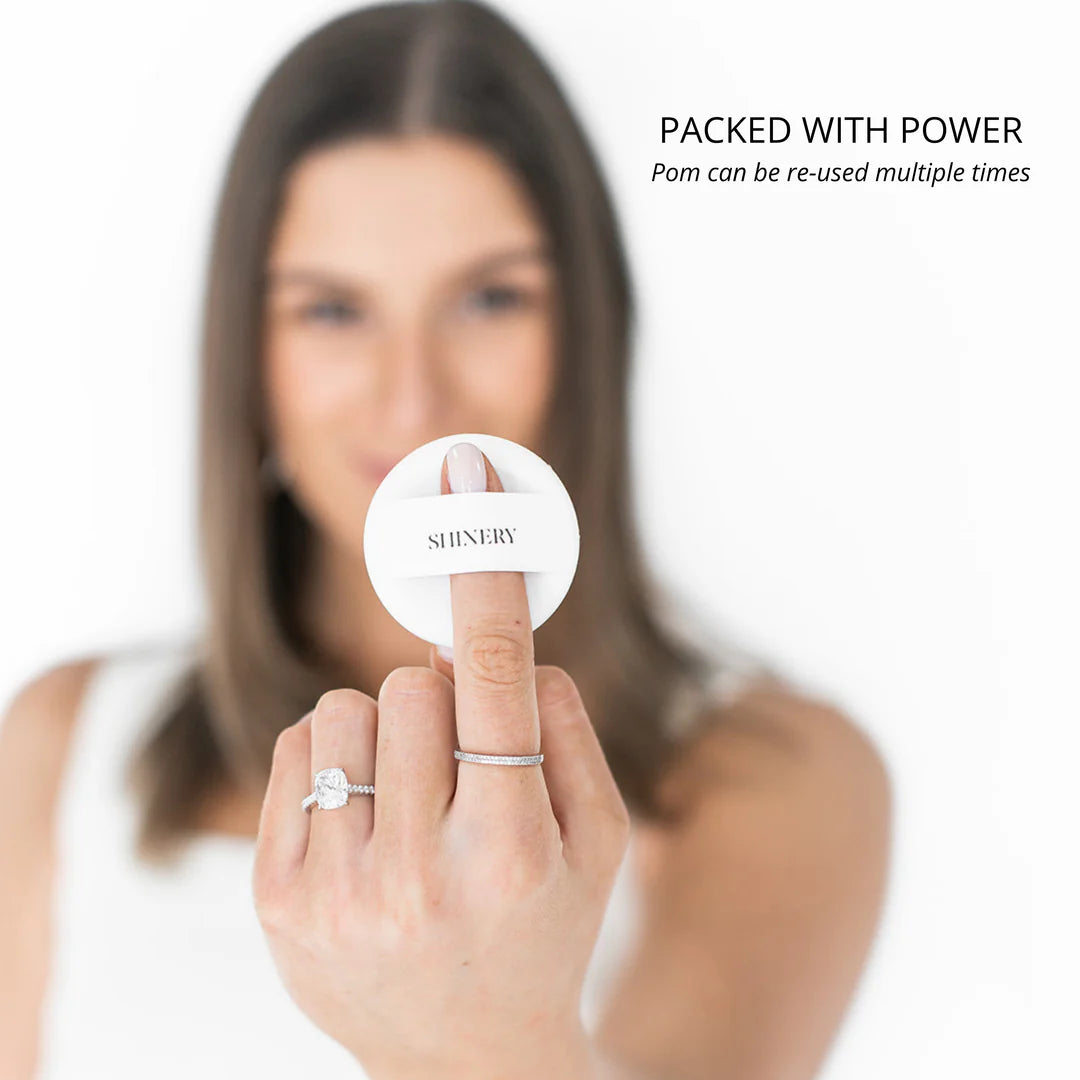 Person holding shinery illuminating pom on their finger