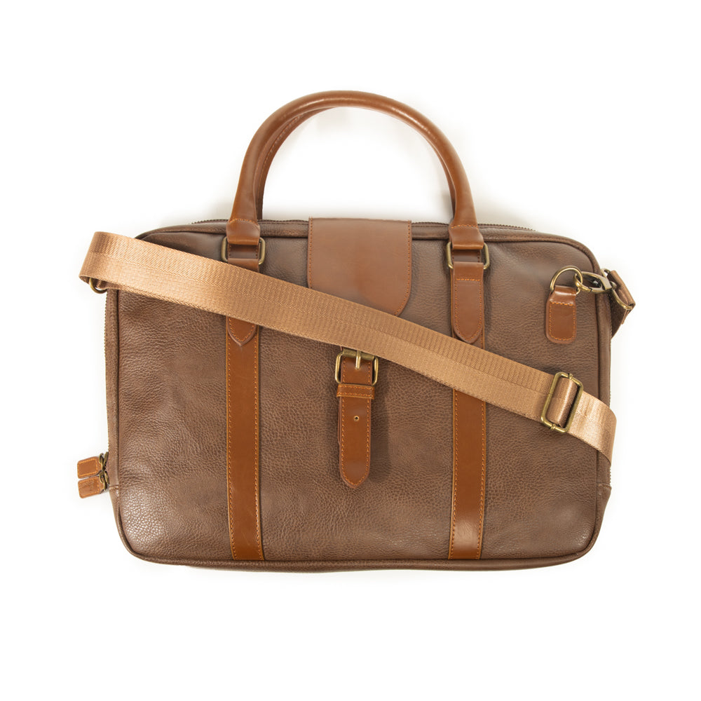 brown laptop case with shoulder strap laying across it.