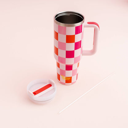 hand holding sweetheart check tumbler with lid off on a white background.