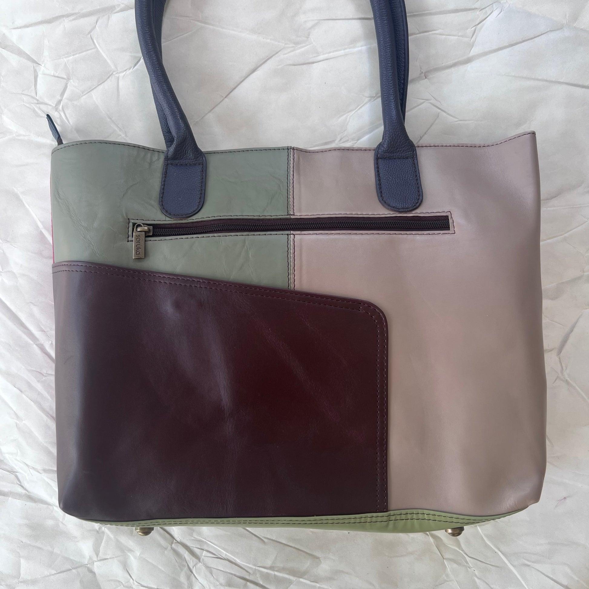 back view of marina sitges tote with color blocks of muted browns and green
