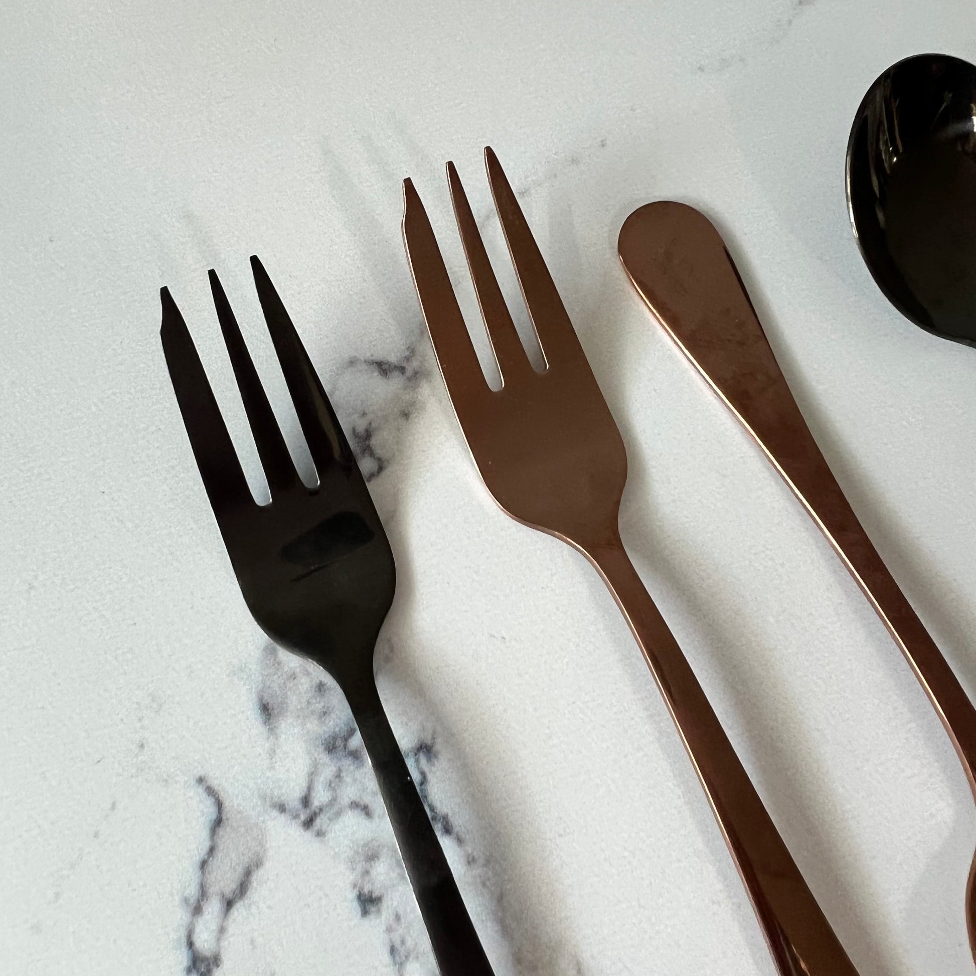 close-up of forks on a marble countertop.
