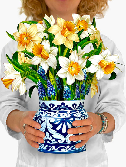 person holding English Daffodils paper bouquet in front of their chest.