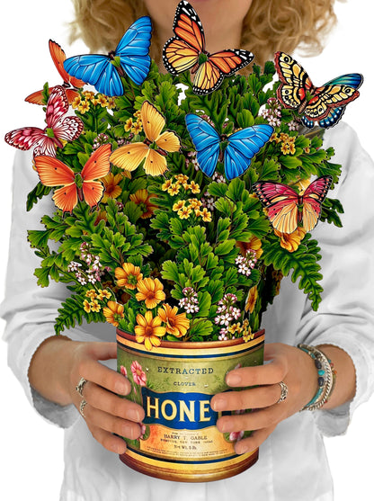 person holding Butterflies & Buttercups paper flower bouquet in front of their chest.