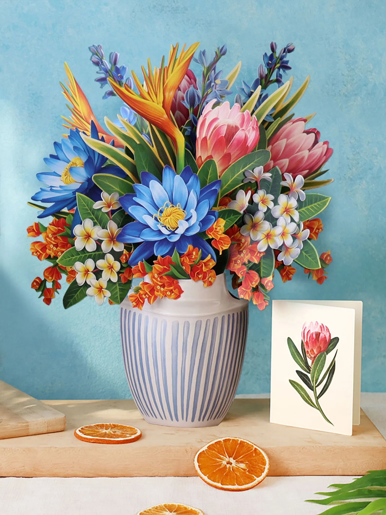 Tropical Paradise Pop-Up Bouquet of paper flowers in vibrant colors of pink, orange, an blue in a white and blue striped vase