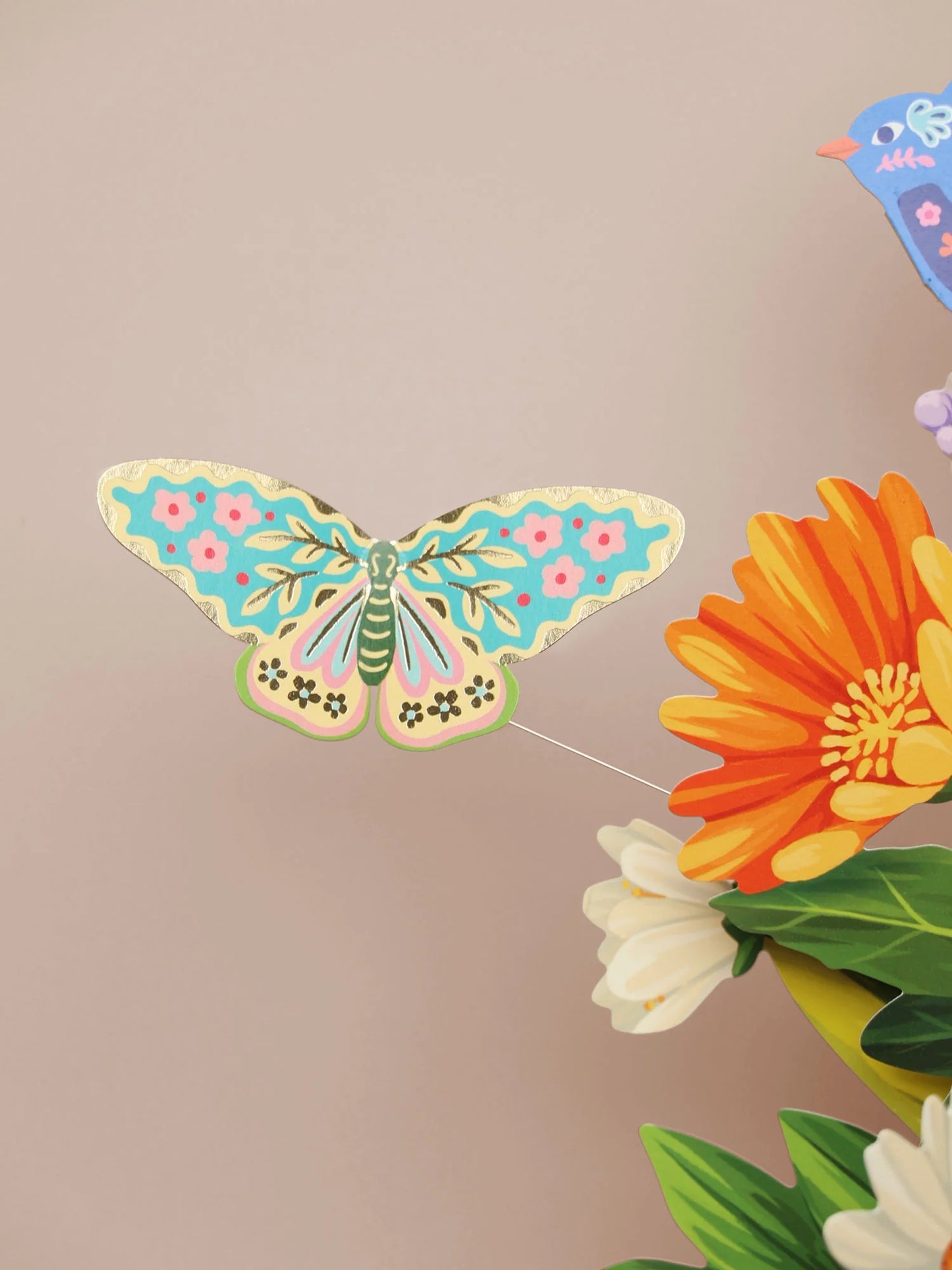 close-up of a blue and yellow butterfly on a wire above the Enchanted Garden Pop-Up Bouquet