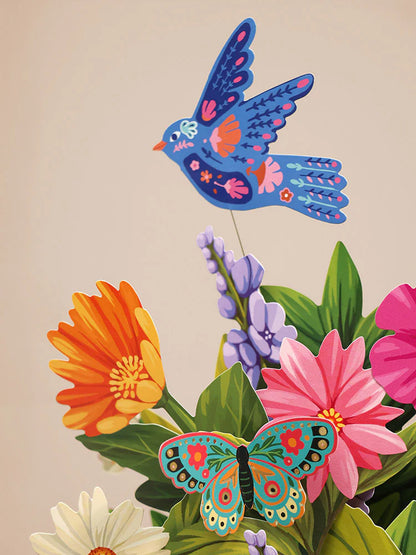 close-up of a blue paper bird on a wire above the Enchanted Garden Pop-Up Bouquet