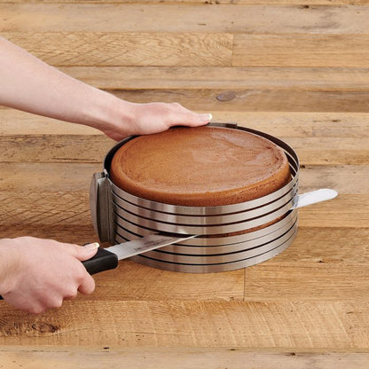 hand holding knife and slicing a round cake in cake slicer