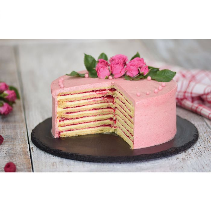 strawberry layer cake on a black marble plate with roses on top