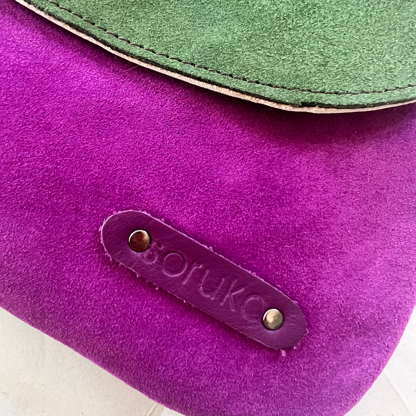 close-up of corner of purse showing "soruka" logo.