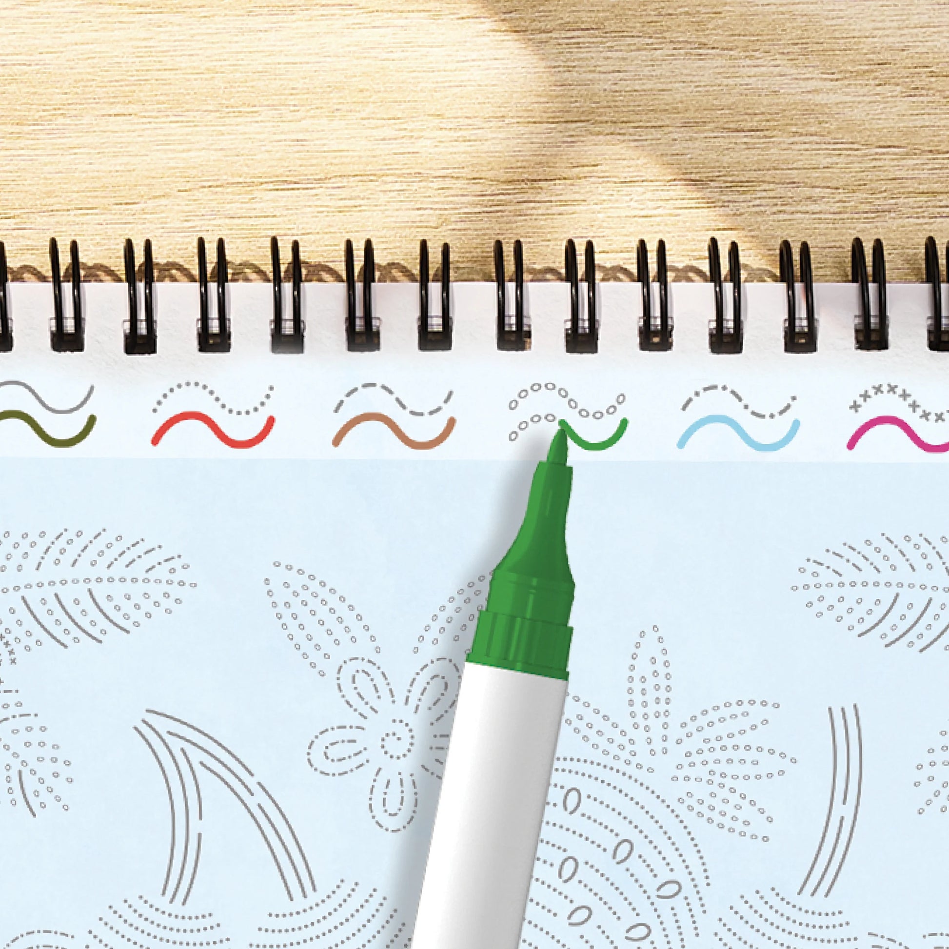green marker with green ink being used on a patterned line