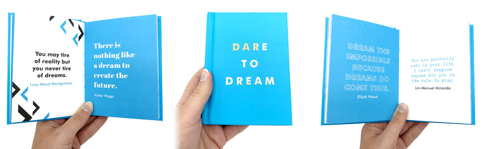 Blue book titled 'Dare to Dream' held by hands on a white background