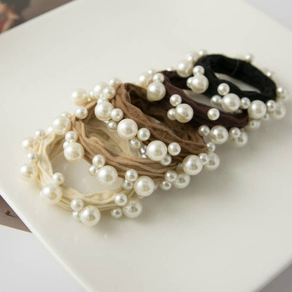 5 hair neutral colored hair ties in a row on a white tray