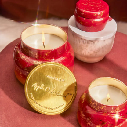 several Apple Cider Social Glimmer Candles arranged on a table.