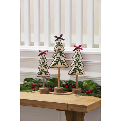 all three sizes of embroidered holly tree sitters displayed on a wooden hall table with holly swag