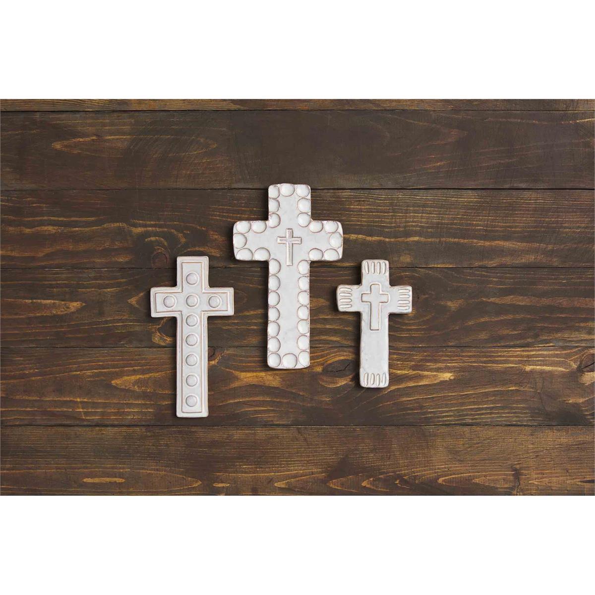 all three sizes of cross sitters displayed on a dark stained wood slat surface