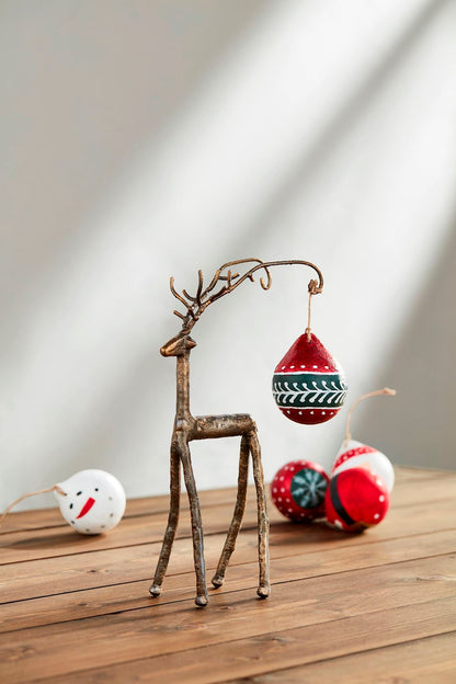 metal deer with ornament hanging from antler.