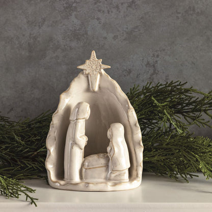 White Stoneware Nativity Set arranged with greenery on a table.