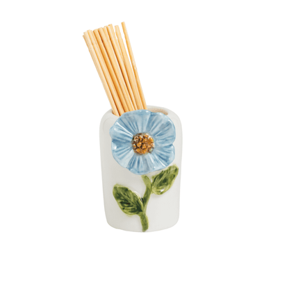 white ceramic holder with blue flower and green leaf design holding wooden toothpicks shown on a white background