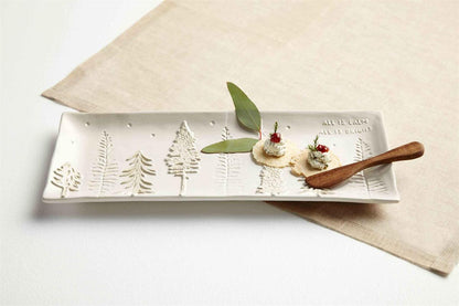 off-white hostess tray with crackers and cheese on it arranged on a table with a linen runner and a wooden spreader.