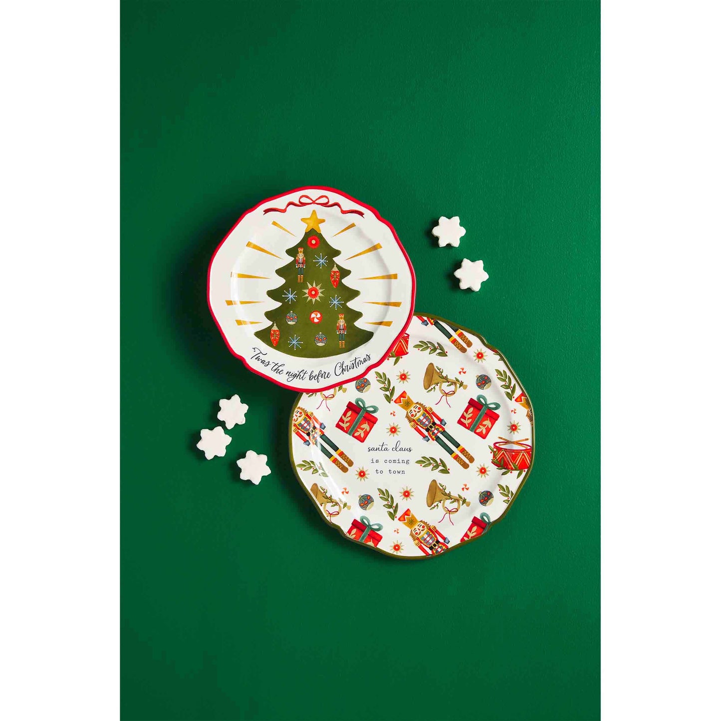 both styles of christmas platters on a green background with cookies scattered around them.