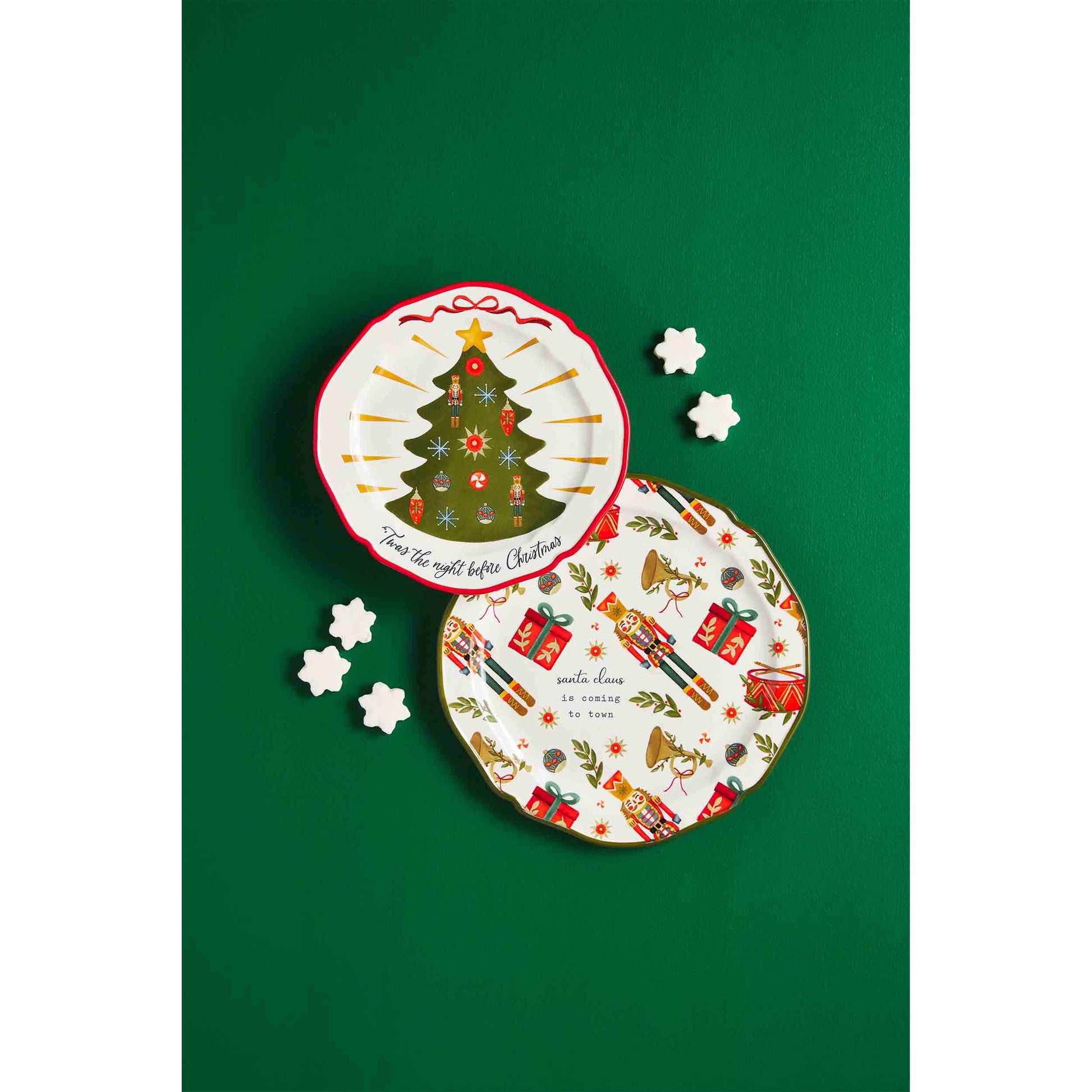 both styles of christmas platters on a green background with cookies scattered around them.