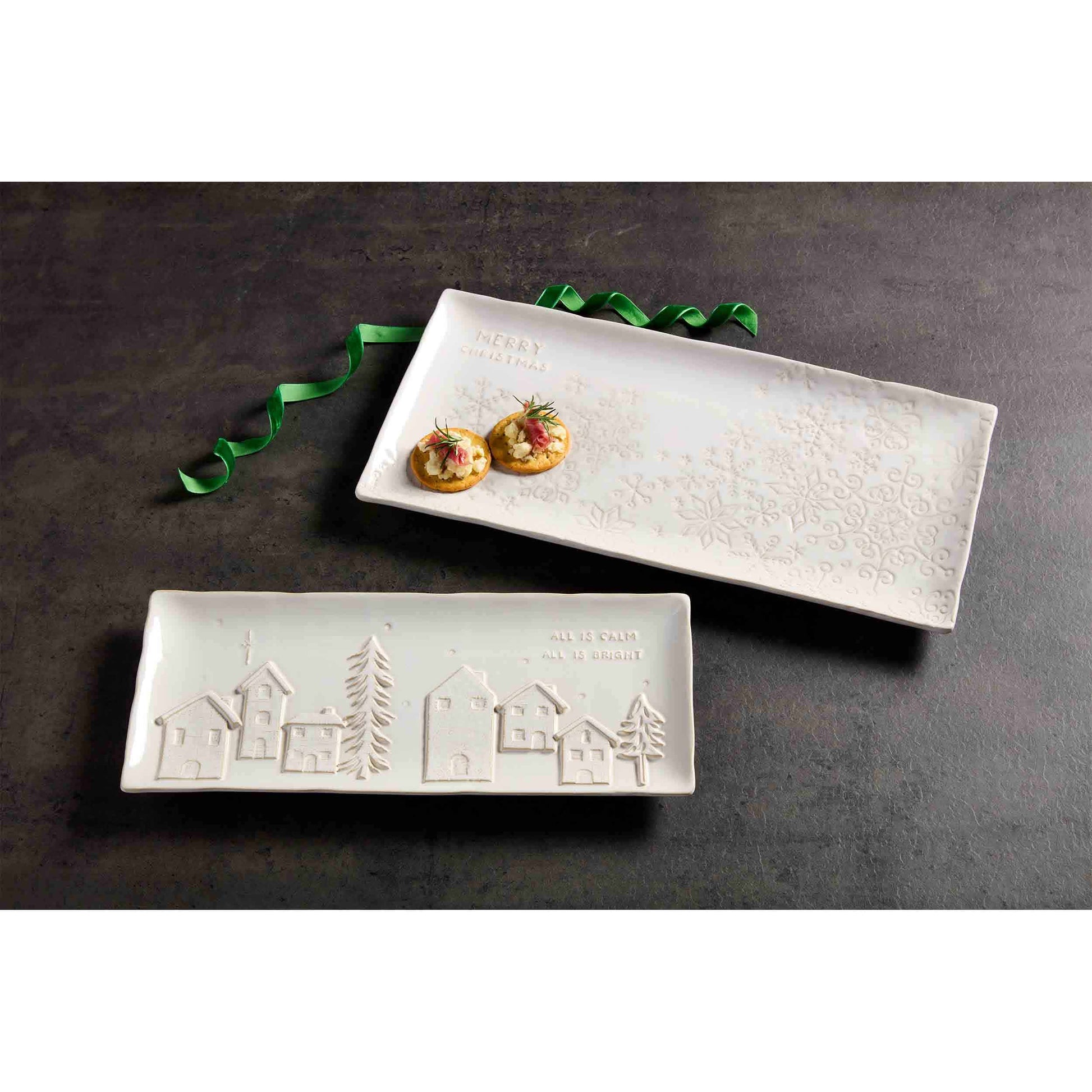 both styles of trays on a dark grey countertop with a curled bit of green velvet ribbon, the larger tray has crackers on it.