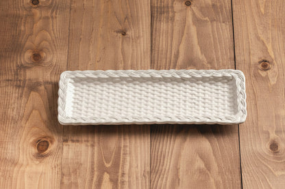 smaller White woven tray on a wooden surface