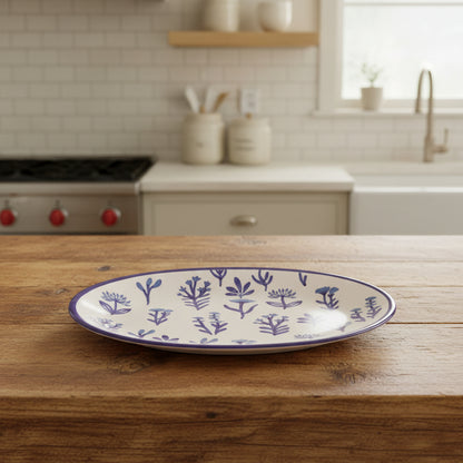 white ceramic oval platter with blue flowers and blue rim set on a kitchen counter