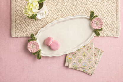 flower handle tray with pink cookie on it set on a pink surface with napkins and flowers