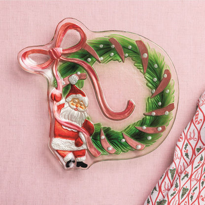 Glass Santa Bow Wreath Platter shown on a pale pink background