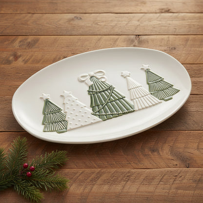 white christmas tree platter on a wooden surface with a sprig of greenery