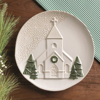 church platter on a wooden table with linens and greenery