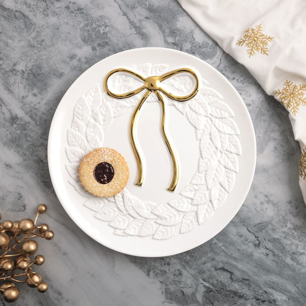 white wreath platter with embossed gold bow shown on a marble surface