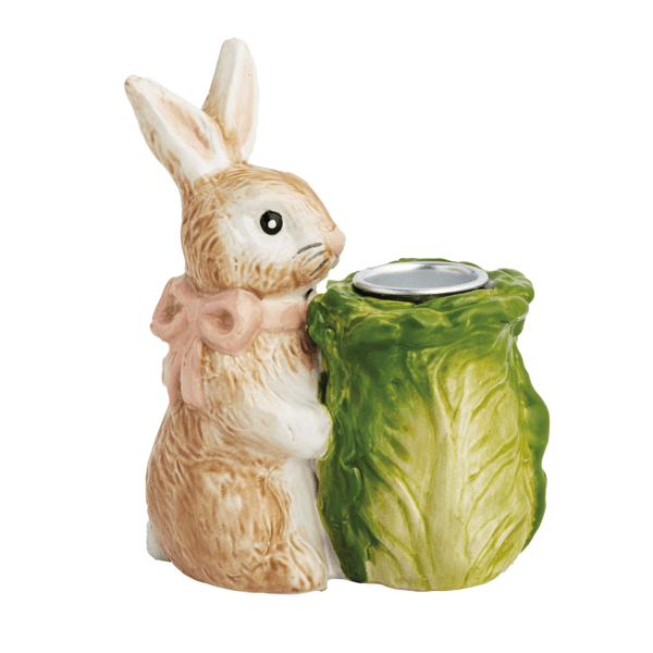 Ceramic rabbit holding a green cabbage-shaped taper holder on a white background
