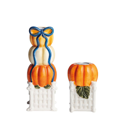2 pumpkin taper candle holders on a white background