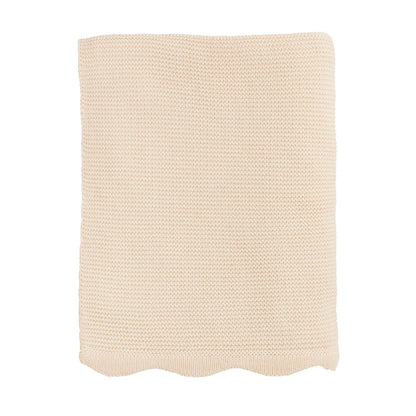 cream colored knitted blanket on a white background