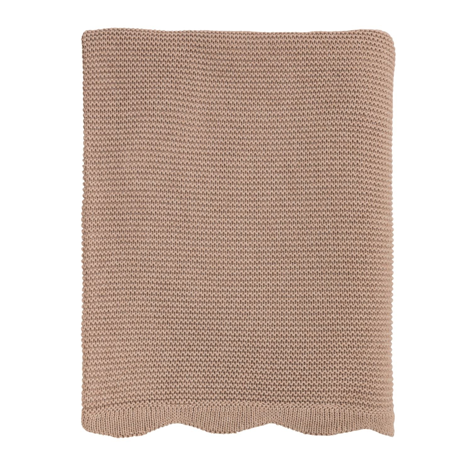 Knitted blanket with a scalloped edge in a neutral color on a white background