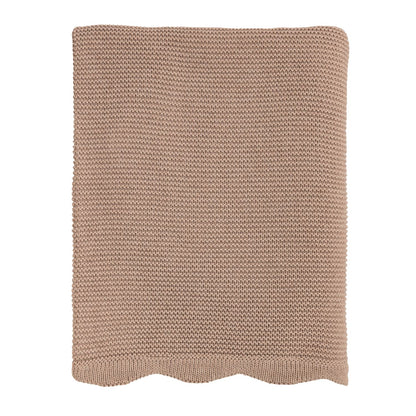 Knitted blanket with a scalloped edge in a neutral color on a white background