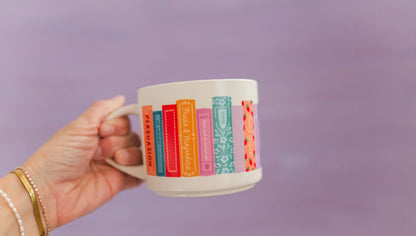 hand holding Jane Austen Books Ceramic Mug in front of lavender background