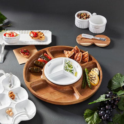 4 section lazy susan filled with snacks and set on a table with other dishes.