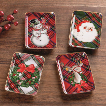 4 tartan enamel trays with holiday scenes on a wood table