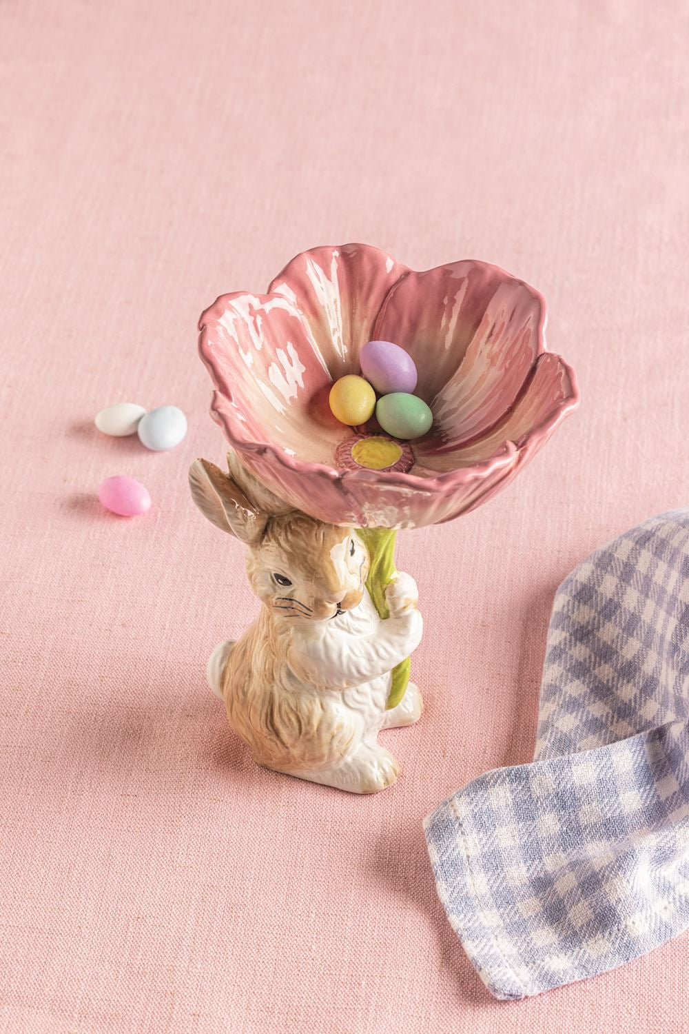bunny flower candy bowl with candy in it set on a pink background