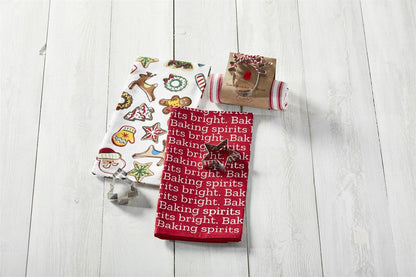 christmas towels and cookie cutter arranged on a wood slat background.